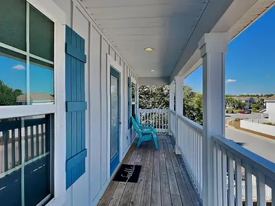 a porch with a blue chair on a house at Southern Charm in Inlet Beach