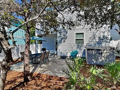 a patio with a table and chairs in front of a house at Southern Charm in Inlet Beach