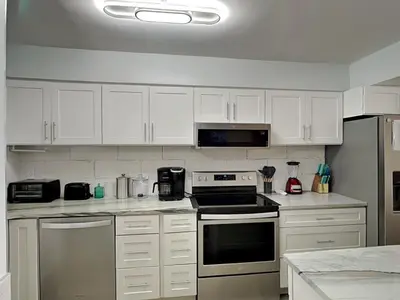 a kitchen with white cabinets and a stove top oven at Regency Towers PCB #1006 in Panama City Beach
