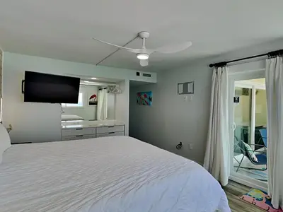 a bedroom with a bed and a flat screen tv at Regency Towers PCB #1006 in Panama City Beach