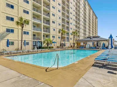 a swimming pool in front of a large apartment building at Regency Towers PCB #1006 in Panama City Beach