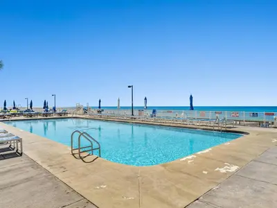 a large swimming pool with the ocean in the background at Regency Towers PCB #1006 in Panama City Beach