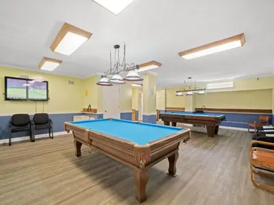 a billiard room with two pool tables and chairs at Regency Towers PCB #1006 in Panama City Beach