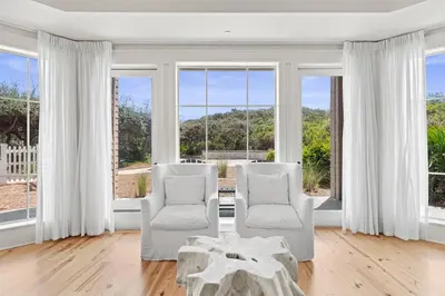 two chairs and a table in a room with windows at 37 Compass Point South #107 in Inlet Beach