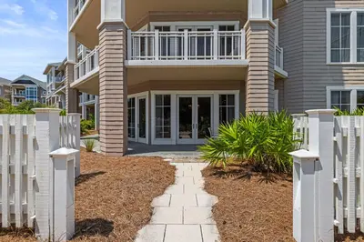 a house with a white fence in front of it at 37 Compass Point South #107 in Inlet Beach