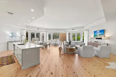 a kitchen and living room with white walls and hardwood floors at 37 Compass Point South #107 in Inlet Beach