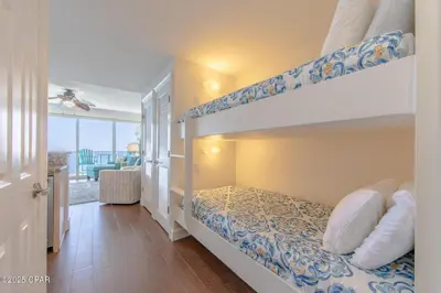 a bedroom with a bunk bed and a balcony at Boardwalk 2205 in Panama City Beach