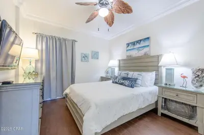 a bedroom with a bed and a ceiling fan at Boardwalk 2205 in Panama City Beach