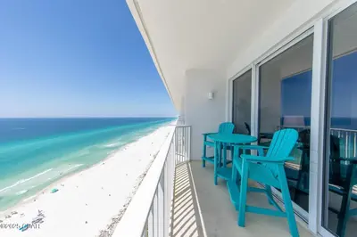 a balcony with blue chairs and a view of the beach at Boardwalk 2205 in Panama City Beach