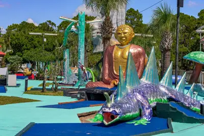a statue of a buddha and a lizard in a water park at Salty Soul in Panama City Beach