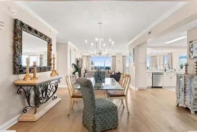 a dining room and living room with a table and chairs at Hidden Dunes #201 in Panama City Beach