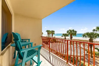 a blue rocking chair on a balcony with the beach at Hidden Dunes #201 in Panama City Beach
