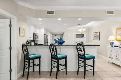 a kitchen with two bar stools and a counter at Treasure Island #2303 in Panama City Beach