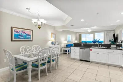 a kitchen and dining room with a table and chairs at Treasure Island #2303 in Panama City Beach