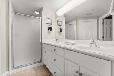a white bathroom with two sinks and a large mirror at Treasure Island #2303 in Panama City Beach