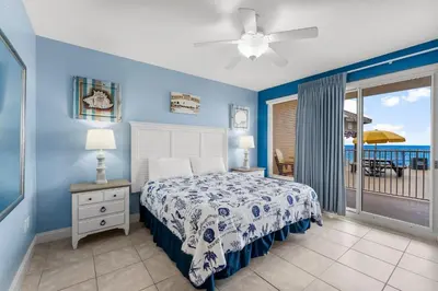 a bedroom with a bed and a view of the ocean at Treasure Island #0106 in Panama City Beach