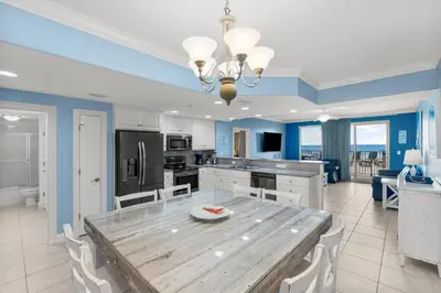a large kitchen with a wooden table and chairs at Treasure Island #0106 in Panama City Beach