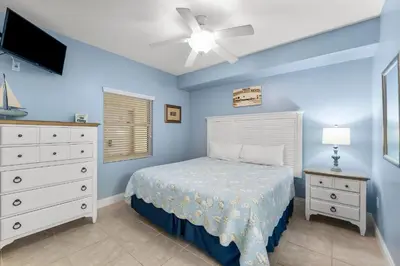 a bedroom with a bed and a ceiling fan at Treasure Island #0106 in Panama City Beach