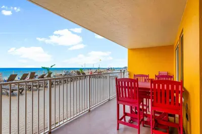 a balcony with a table and chairs and the beach at Treasure Island #0106 in Panama City Beach