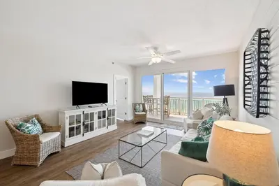 a living room with a couch and a television at HP 34W On the Shore by 30A Escapes in Rosemary Beach