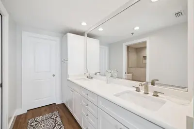 a white bathroom with two sinks and a mirror at HP 34W On the Shore by 30A Escapes in Rosemary Beach