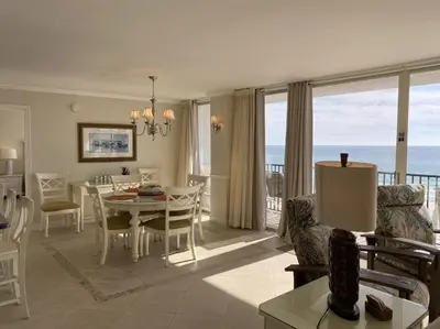 a dining room and living room with a view of the ocean at Seachase E301 by Emerald Coast Retreats in Panama City Beach