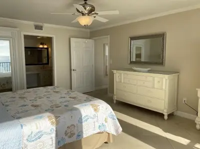 a bedroom with a bed and a dresser and a mirror at Seachase E301 by Emerald Coast Retreats in Panama City Beach