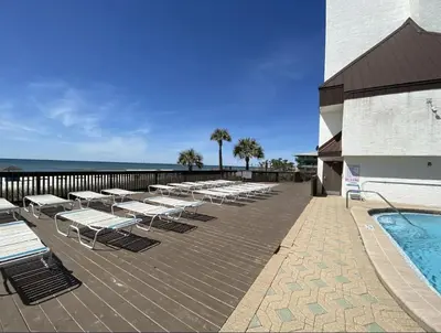 a deck with lounge chairs and a swimming pool at Seachase E301 by Emerald Coast Retreats in Panama City Beach