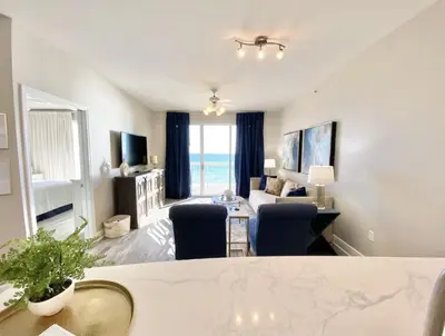 a living room with a couch and a table at Celadon 405 by Emerald Coast Retreats in Panama City Beach