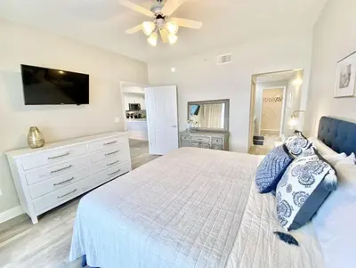 a bedroom with a large bed with a ceiling fan at Celadon 405 by Emerald Coast Retreats in Panama City Beach
