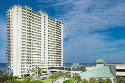 a large white building with the ocean in the background at Celadon 405 by Emerald Coast Retreats in Panama City Beach