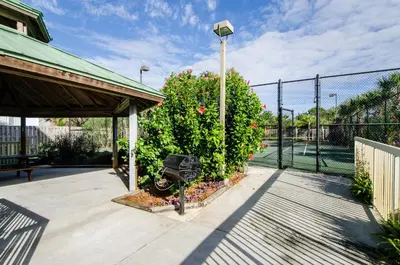 a patio with a fence and a bush with flowers at Celadon 405 by Emerald Coast Retreats in Panama City Beach