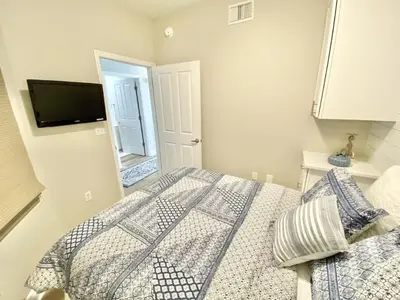 a bedroom with a bed and a tv on the wall at Celadon 2005 by Emerald Coast Retreats in Panama City Beach