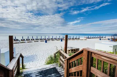 a view of a sandy beach with a wooden stairway at Celadon 2005 by Emerald Coast Retreats in Panama City Beach