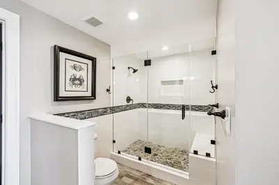 a white bathroom with a shower and a toilet at HP 35W Gulf Front Condo by 30A Escapes in Rosemary Beach