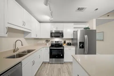 a kitchen with white cabinets and a stainless steel refrigerator at Laketown Wharf #1826 in Panama City Beach