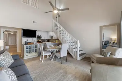 a living room with a staircase and a dining room at 30A Eastern Shores Condominiums by Panhandle Getaways in Santa Rosa Beach