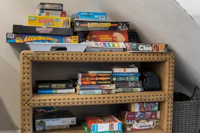 a stack of books on a book shelf at 30A Eastern Shores Condominiums by Panhandle Getaways in Santa Rosa Beach