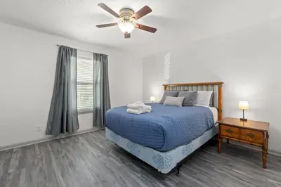 a bedroom with a bed and a ceiling fan at Bombastic Beach Bungalow, 10 Min WALK to the Beach in Panama City Beach