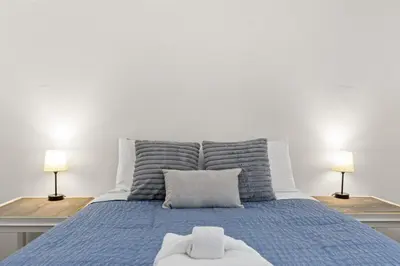a bedroom with a blue bed with two lamps at Bombastic Beach Bungalow, 10 Min WALK to the Beach in Panama City Beach