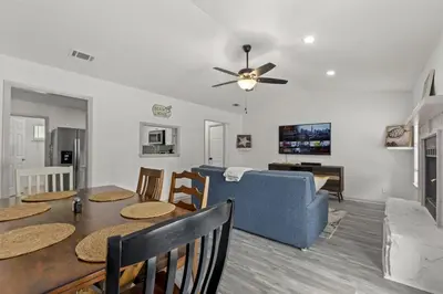 a living room with a table and a blue couch at Bombastic Beach Bungalow, 10 Min WALK to the Beach in Panama City Beach
