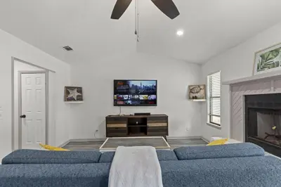 a living room with two blue couches and a tv at Bombastic Beach Bungalow, 10 Min WALK to the Beach in Panama City Beach
