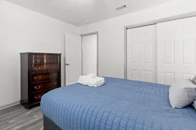 a bedroom with a blue bed and a dresser at Bombastic Beach Bungalow, 10 Min WALK to the Beach in Panama City Beach