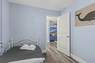 a bedroom with a bed with two towels on it at Bombastic Beach Home, HOT TUB, 8min WALK to Beach in Panama City Beach