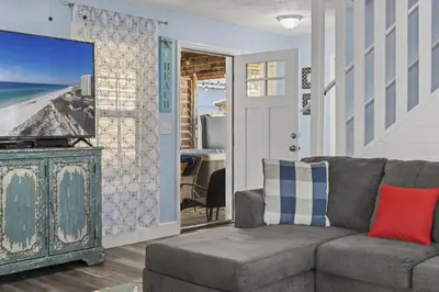 a living room with a couch and a tv at Bombastic Beach Home, HOT TUB, 8min WALK to Beach in Panama City Beach