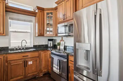 a kitchen with wooden cabinets and a stainless steel refrigerator at Saltwater Therapy on 30A by 30A Escapes in Seacrest