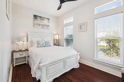 a white bedroom with a bed and two windows at Saltwater Therapy on 30A by 30A Escapes in Seacrest