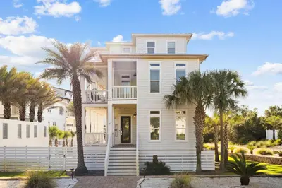 a white house with palm trees in front of it at Saltwater Therapy on 30A by 30A Escapes in Seacrest