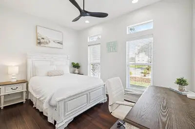 a bedroom with a white bed and a desk and a chair at Saltwater Therapy on 30A by 30A Escapes in Seacrest