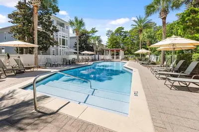 a swimming pool with chairs and umbrellas at a hotel at Seagrove Escape Refreshed plus Shared Pool in Seagrove Beach